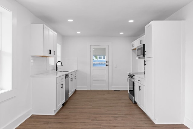 2917 Crescent Cir, Chattanooga, TN 37407 - kitchen with appliances with stainless steel finishes, wood finished floors, a sink, light countertops, and recessed lighting