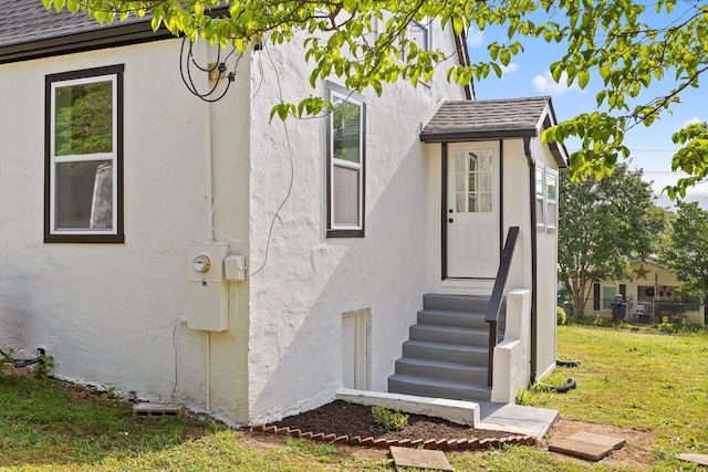 2917 Crescent Cir, Chattanooga, TN 37407 - view of side of property featuring a lawn, roof with shingles, stucco siding, and entry steps