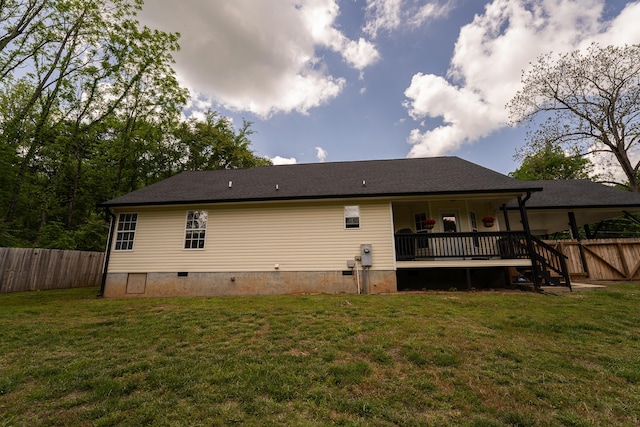 rear view of house with a lawn, fence, and crawl space