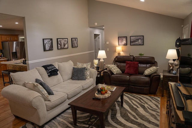 living area featuring light wood-style floors, recessed lighting, and vaulted ceiling