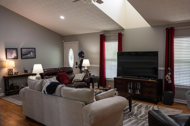 living room featuring wood finished floors, baseboards, recessed lighting, a ceiling fan, and vaulted ceiling