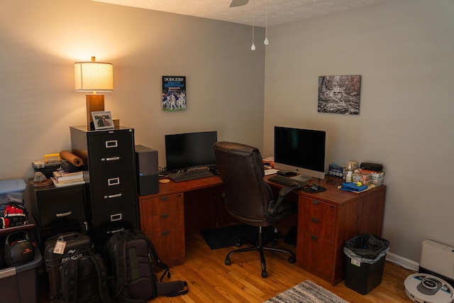office featuring a textured ceiling, ceiling fan, and wood finished floors