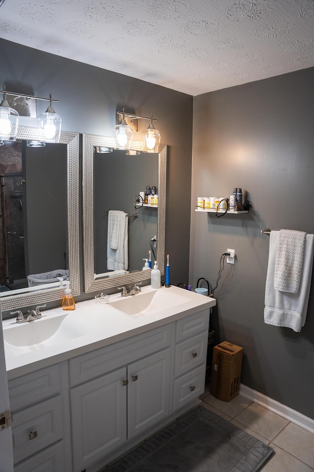full bath featuring double vanity, tile patterned floors, a sink, and a textured ceiling