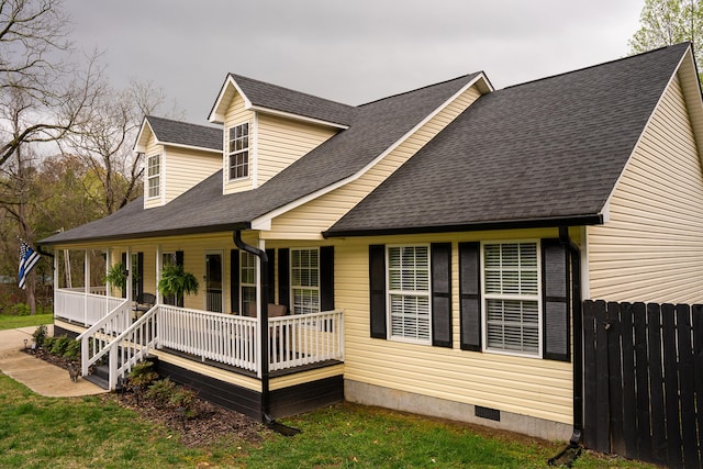 exterior space featuring fence, covered porch, and a shingled roof
