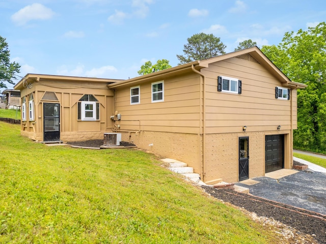 1852 N Prairie Cir, Hixson, TN 37343 - back of house with a garage, driveway, a lawn, and central air condition unit