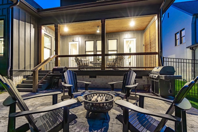 view of patio featuring grilling area, covered porch, and a fire pit