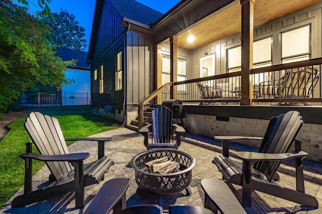 patio at twilight featuring fence and a fire pit