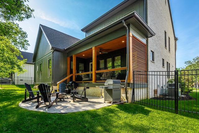 back of house featuring fence, roof with shingles, ceiling fan, a patio area, and a lawn