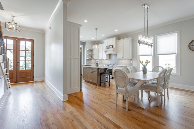 dining room featuring crown molding, baseboards, recessed lighting, light wood-type flooring, and a notable chandelier
