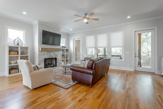 living room with light wood finished floors, ceiling fan, and a healthy amount of sunlight