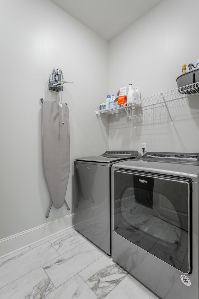 laundry area with laundry area, marble finish floor, baseboards, and washer and dryer