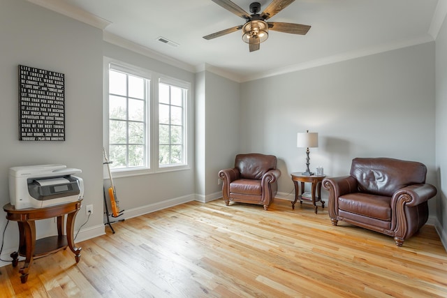 sitting room with visible vents, crown molding, baseboards, ceiling fan, and light wood finished floors