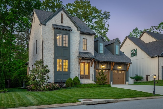 view of front facade featuring brick siding, a yard, and concrete driveway
