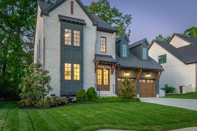 view of front of house featuring concrete driveway, brick siding, an attached garage, and a front yard
