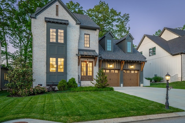 view of front of home featuring brick siding, an attached garage, driveway, and a front yard
