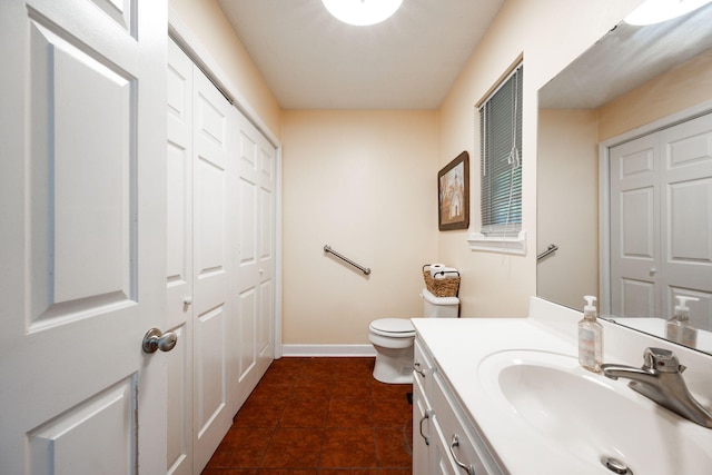 bathroom with toilet, baseboards, tile patterned floors, and vanity