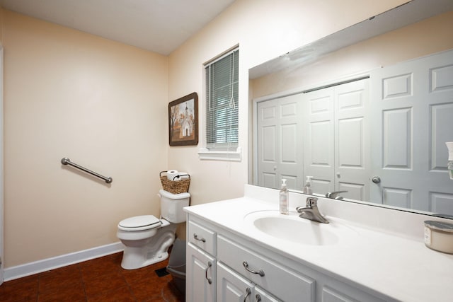 bathroom with toilet, tile patterned floors, baseboards, and vanity