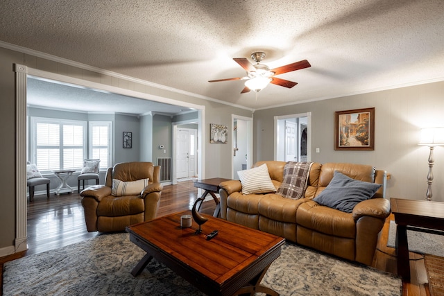 living room featuring crown molding, a ceiling fan, a textured ceiling, and wood finished floors