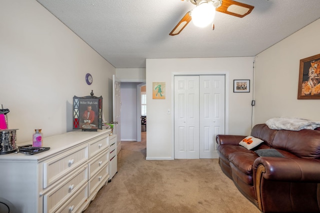interior space featuring baseboards, a ceiling fan, and light carpet