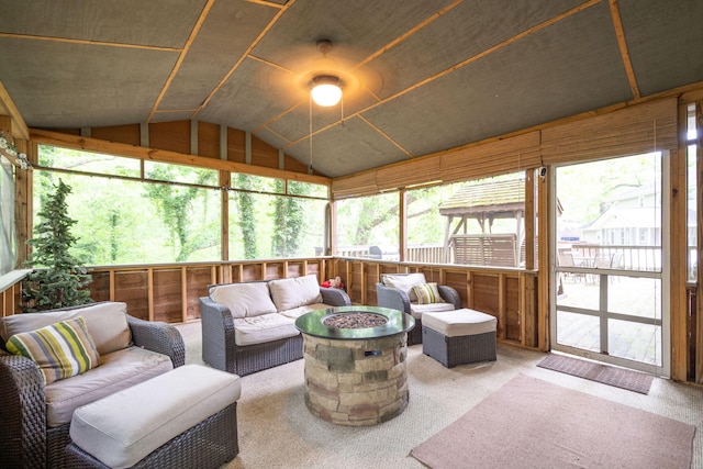 sunroom with a ceiling fan and an outdoor living space with a fire pit