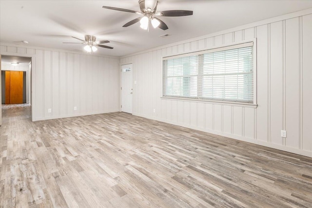 spare room with visible vents, ornamental molding, ceiling fan, and wood finished floors