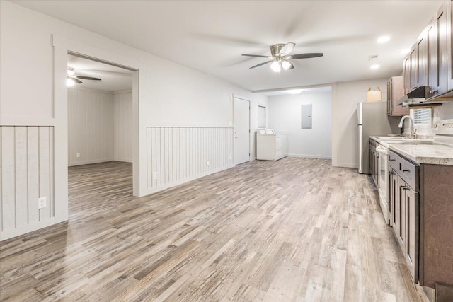 kitchen with a ceiling fan, separate washer and dryer, light wood-style flooring, and electric panel