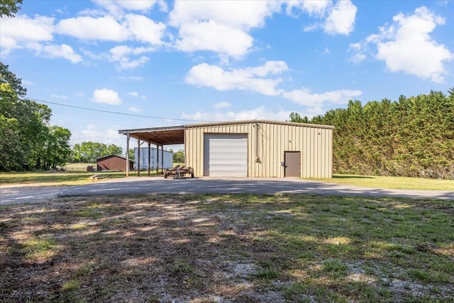 garage with driveway and a detached garage