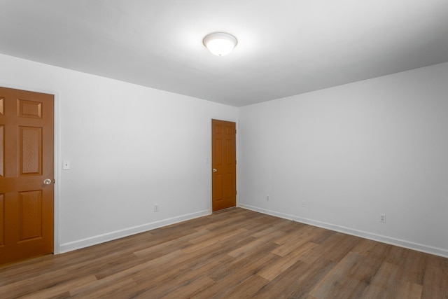 unfurnished room with baseboards and wood finished floors