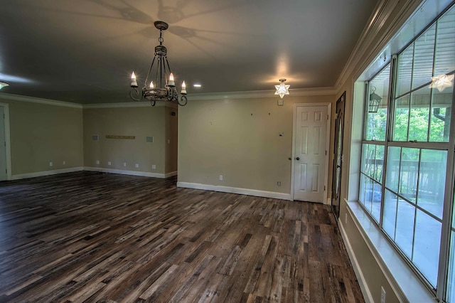 spare room with crown molding, dark wood-style flooring, and a chandelier