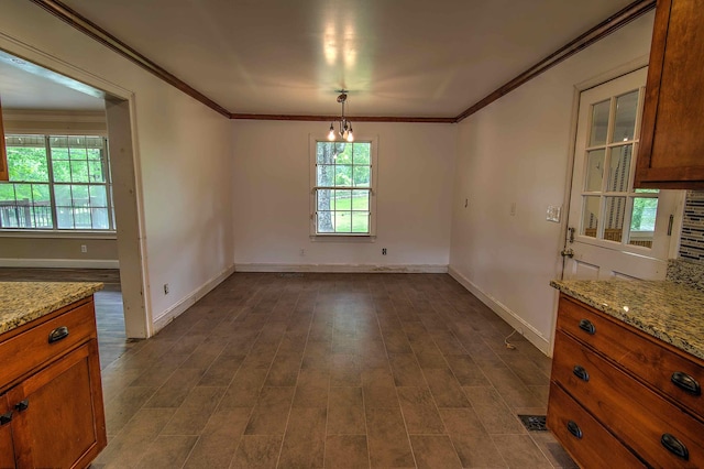 unfurnished dining area with crown molding, baseboards, and plenty of natural light