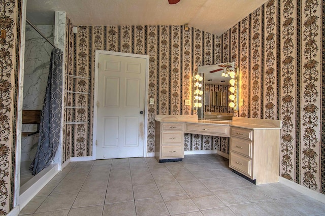 bathroom featuring tile patterned flooring, a marble finish shower, baseboards, wallpapered walls, and vaulted ceiling