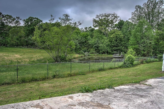 view of yard with a forest view and fence