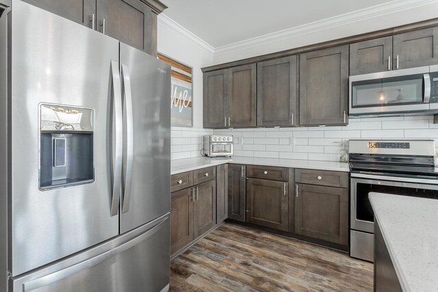 1826 Seven Pines Ln, Chattanooga, TN 37415 - kitchen featuring appliances with stainless steel finishes, crown molding, tasteful backsplash, dark brown cabinets, and dark wood-type flooring