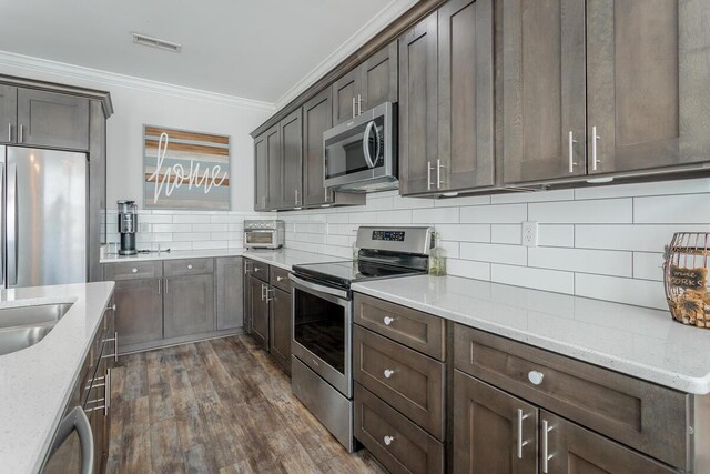 1826 Seven Pines Ln, Chattanooga, TN 37415 - kitchen with appliances with stainless steel finishes, crown molding, backsplash, dark wood-type flooring, and light stone countertops