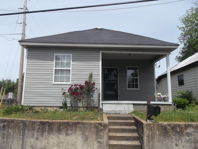view of front of house featuring roof with shingles and a porch
