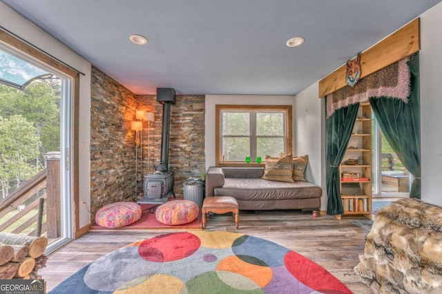 sitting room with recessed lighting, wood finished floors, and a wood stove