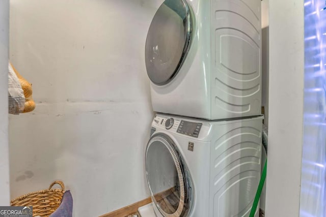 laundry room with stacked washer and dryer and laundry area
