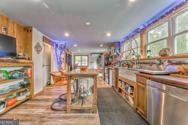 kitchen with light wood-style floors, brown cabinets, stainless steel dishwasher, and recessed lighting