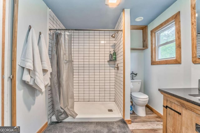 full bath featuring vanity, baseboards, a stall shower, and toilet