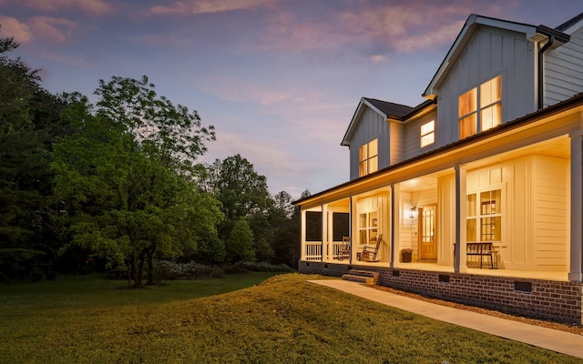 6949 Sawyer Rd, Signal Mountain, TN 37377 - back of property at dusk featuring board and batten siding, covered porch, crawl space, and a yard