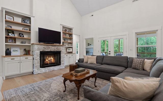 6949 Sawyer Rd, Signal Mountain, TN 37377 - living area featuring french doors, a fireplace, light wood-style flooring, high vaulted ceiling, and built in shelves