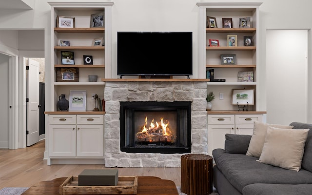 6949 Sawyer Rd, Signal Mountain, TN 37377 - living area featuring light wood-style flooring, a stone fireplace, and built in shelves