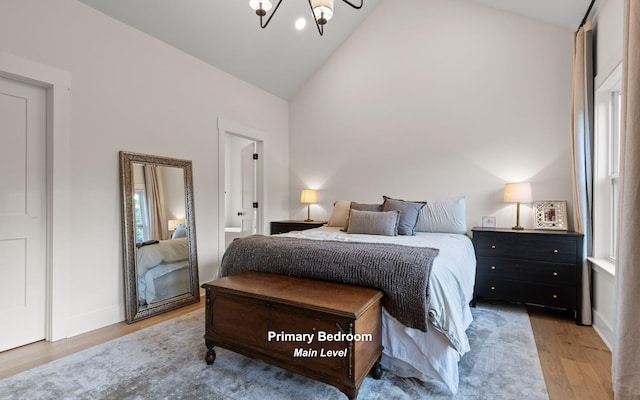 6949 Sawyer Rd, Signal Mountain, TN 37377 - bedroom with light wood-style flooring, high vaulted ceiling, and a chandelier
