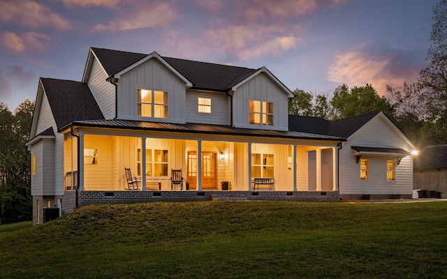 6949 Sawyer Rd, Signal Mountain, TN 37377 - back of property at dusk featuring crawl space, board and batten siding, covered porch, and a lawn