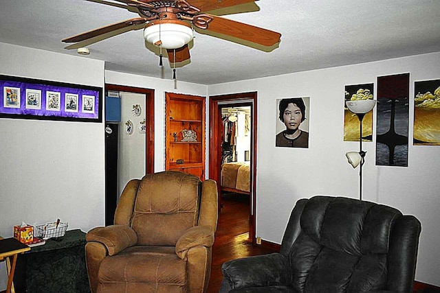 living area with a ceiling fan, wood finished floors, and baseboards