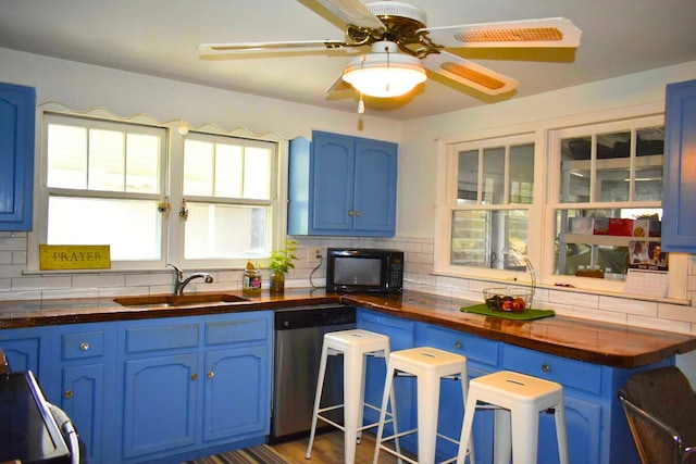 kitchen with blue cabinets, dishwasher, butcher block counters, a sink, and black microwave