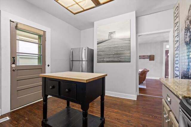 kitchen with visible vents, wooden counters, baseboards, dark wood-style floors, and appliances with stainless steel finishes