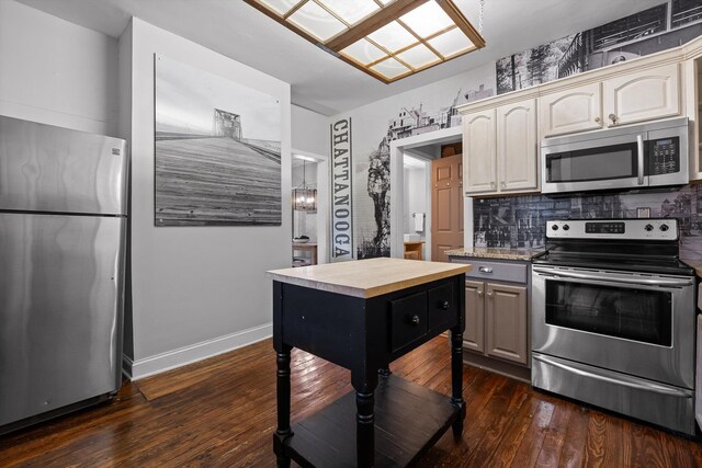 kitchen featuring appliances with stainless steel finishes, butcher block countertops, baseboards, dark wood-type flooring, and backsplash