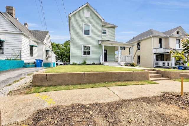 traditional-style house with a porch and a front lawn