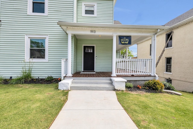 property entrance featuring covered porch and a yard